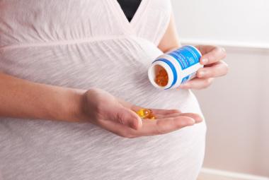 Pregnant mom showing fish oils